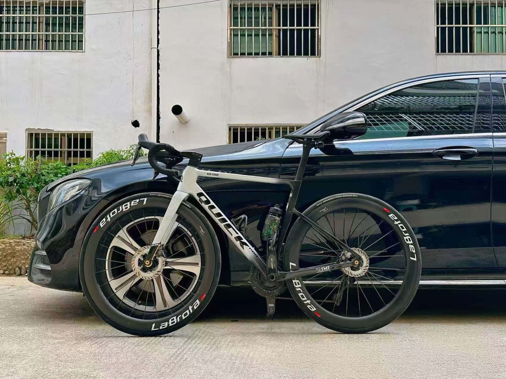 LaBrota owner moment - bike beside black car, watermark-free full image